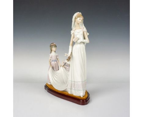 Glazed figure of a bride and two girls helping her with the wedding dress. Lladro backstamp. This item has a base included: 1