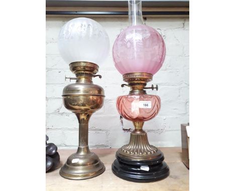 A brass and glass paraffin lamp, with etched glass shade, on ceramic black stepped base together with a brass paraffin lamp w