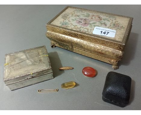 A vintage footed metal and tapestry top jewellery box containing a 9ct gold Baby brooch, 2 yellow metal brooches and a large 