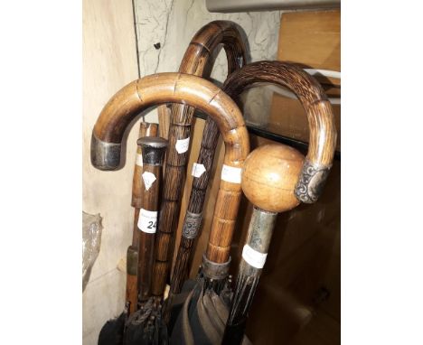 A collection of vintage walking sticks with silver mounts, a sword stick and two vintage parasols with silver mounts. 