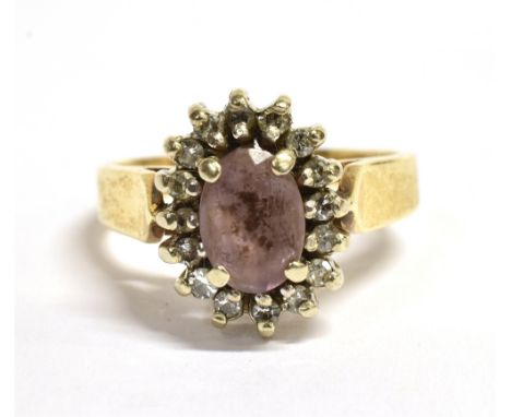 AN ALMANDINE, DIAMOND AND GOLD CLUSTER RING  The oval Almandine measuring 0.7cm x 0.5cm and surrounded by 16 small round cut 