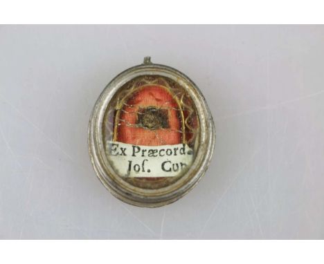 Reliquienkapsel, 18./19. Jh., hochovaler Metallanhänger, facettiertes Sichtfenster mit Reliquie und darunter positioniertem S