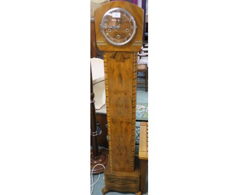 An Art Deco 1930's figured walnut grandmother clock. The Art Deco case having a silvered chapter ring to the face and inset b