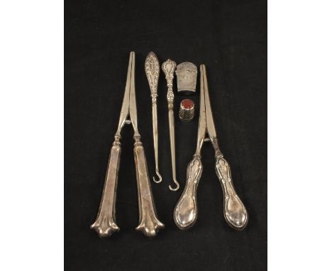 Two pairs of Silver handled glove stretchers, two button hooks, a thimble and a small box
