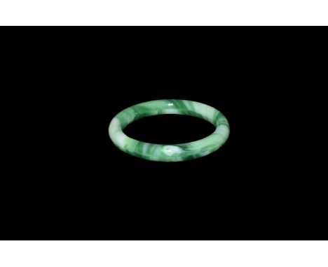 20th century AD. A glass round section bracelet in banded green to imitate jade.   52 grams, 80mm (3 1/4"). Acquired on the L