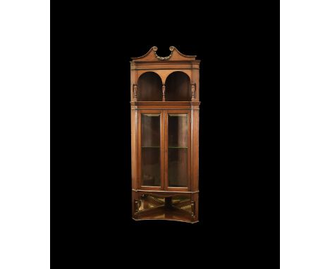 Late 19th-early 20th century AD. A mahogany corner cupboard, triangular in plan with two glazed doors; pediment with carved r