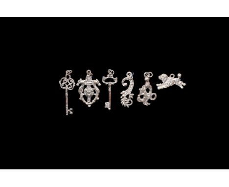 19th century AD. A group of silver amulets comprising: a female head with crown above, framed to the sides by scrolling plant