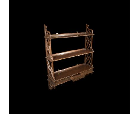 19th century AD. A mahogany wall-mounted shelf unit; three shelves with ledge to the rear and openwork sides, three shallow d