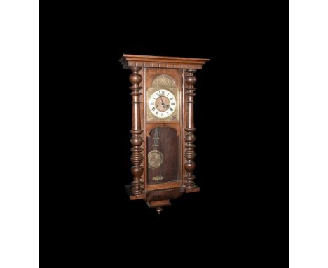 19th century AD. A wooden-framed wall clock with glazed chambers, ornate brass plaque with clock face above, lower chamber wi