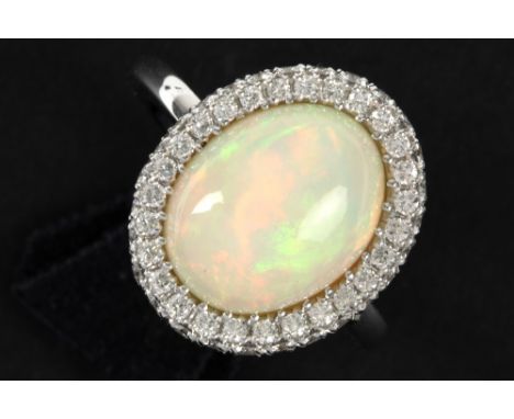 matching ring in white gold (18 carat) with a "full" cabochon cut opal surrounded by 0,81 carat of very high quality brillian