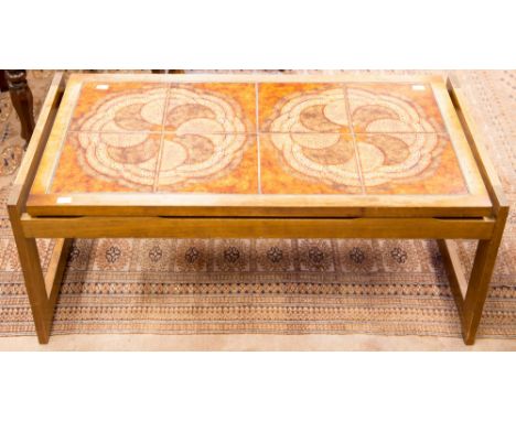 A 1970s teak tile topped coffee table, the top set with brown and orange tiles supported on frame tressle legs