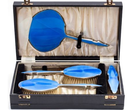 A cased silver and blue enamel dressing table set, comprising hand mirror, brushes and a comb, makers DMG, Birmingham 1935 