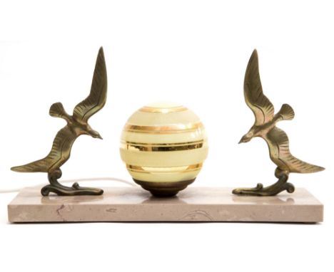 An Art Deco figural table lamp, the beige marble base with two cast  gilt metal birds in flight flanking a central glass sphe