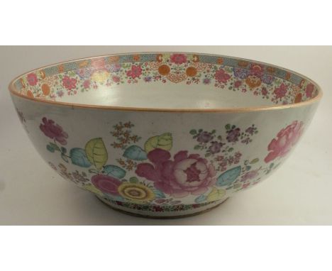 A massive Chinese export punch bowl decorated in famille rose flowers to a light brown rim, diameter 21.25ins, Chip on inside