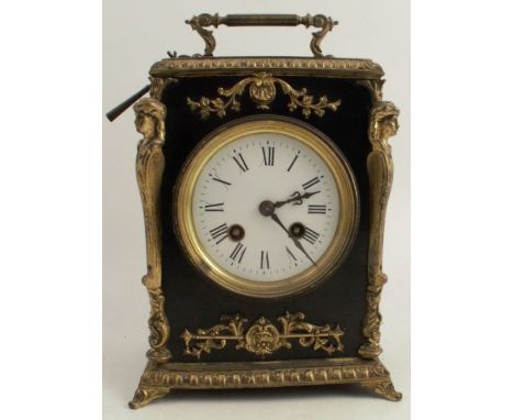 An ebonised mantle clock, with striking movement and circular dial, having Roman numerals, the rectangular case with gilt met