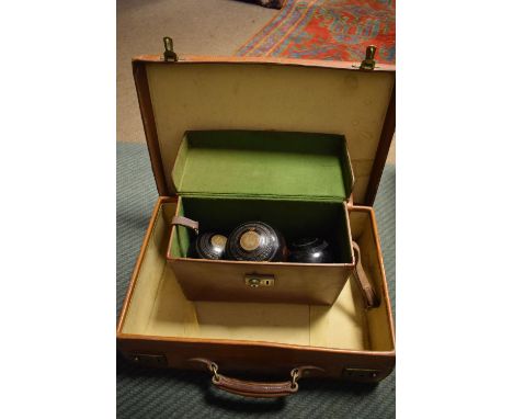 Vintage tan leather suitcase, 51cm wide, together with a cased part set of lawn bowls  