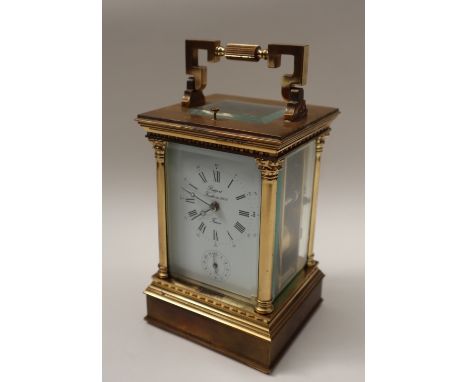 A 20th century brass cased carriage clock, with a circular dial with Roman numerals and alarm dial, with push button repeat, 
