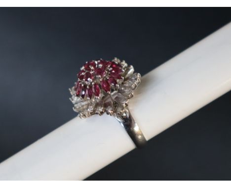 A ruby and diamond dress ring, set with three tiers of round and pointed oval rubies and staggered round old cut diamonds to 