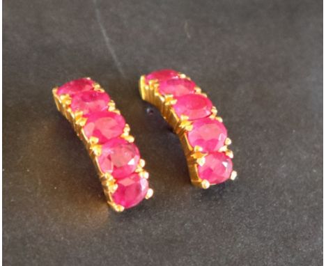 A pair of ruby hoop earrings to a yellow metal setting and post, approximately 4 grams