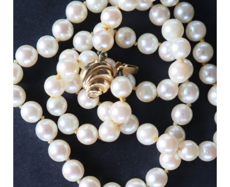 A pearl necklace set with sixty-five regular pearls each approximately 6mm in diameter to an 18ct yellow gold shell shaped cl