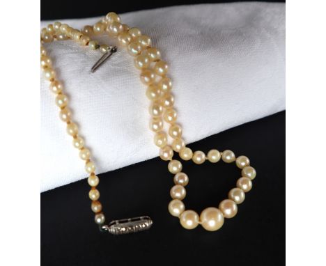 A pearl necklace set with eighty-nine graduated pearls to a sterling silver marcasite set clasp, approximately 48cm long