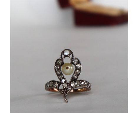 A diamond and pearl dress ring of looping form set with a central pearl and old round and cushion cut diamonds to a yellow me