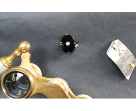 A dress ring set with a central oval onyx panel to a white metal setting and shank, size P, together with mother of pearl ope