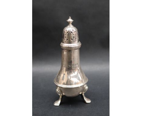 A George V silver pepperette of baluster ring turned form with a turned domed pierced finial on three feet, London, 1924, ins