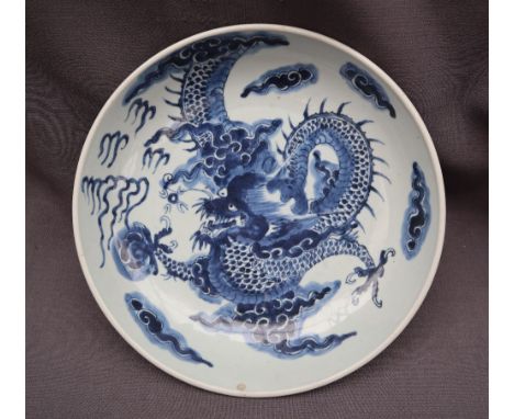 A Chinese porcelain bowl painted to the centre with a four toed dragon chasing a pearl amongst clouds, 28.5cm diameter CONDIT