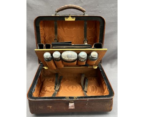 A late Victorian faux crocodile leather vanity case, with a central compartment fitted with silver topped bottles, mother of 