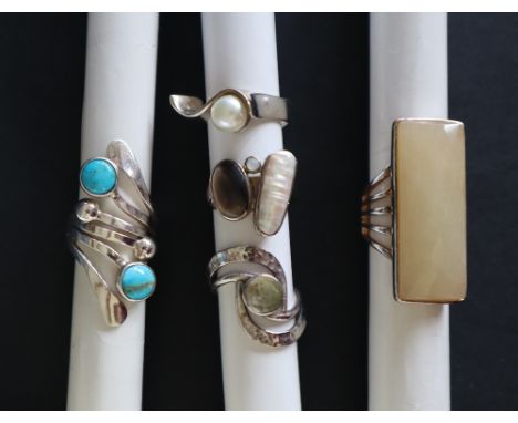 A collection of five silver rings, set with semi precious stones, including turquoise, mother of pearl etc  