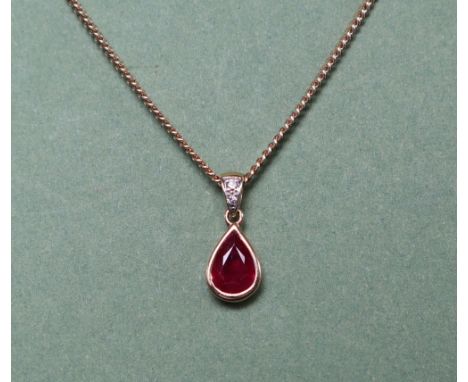 An 18ct gold ruby and diamond pendant, the pear shaped ruby and two round brilliant diamonds on a 9ct yellow gold chain, over