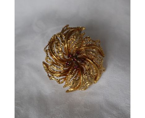 An 18ct yellow gold and ruby set brooch of circular leaf form set with five round faceted rubies, 37mm wide, approximately 10