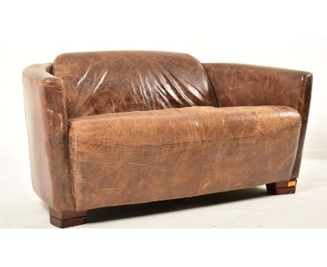 A contemporary British designer two seater sofa settee. The sofa having a canted curved backrest with padded seat. All uphols