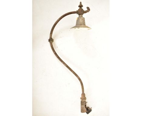 A retro 20th century metal industrial factory yard light lamp. The light having a conical shade over a scrolled S shaped arm 