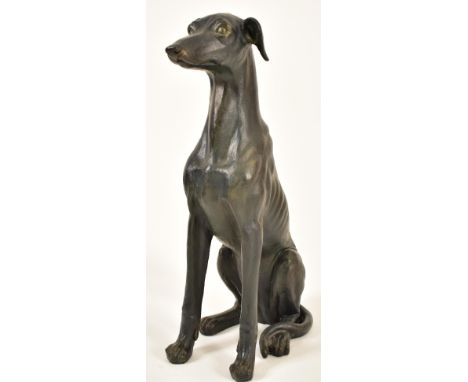 A large 20th century Art Deco influenced resin model of a seated greyhound dog. The floor standing greyhound with moulded fea