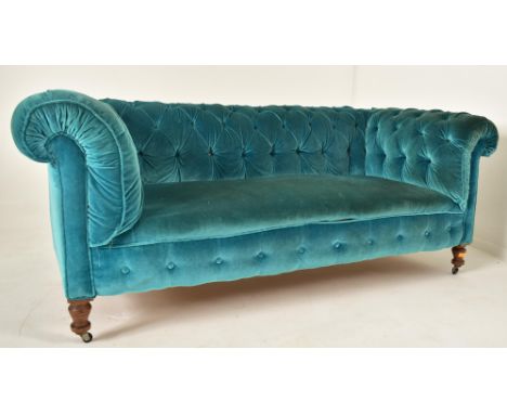 An early 20th century re-upholstered chesterfield three seater sofa settee. The sofa having a scrolled back and armrests with