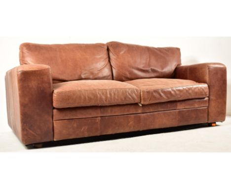 A contemporary British designer two seater sofa settee. The sofa having cushioned seat and backrests with stitched brown leat