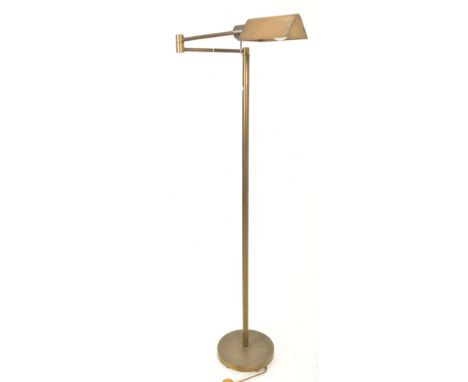 A retro 20th century 1960s inspired brassed metal floor standard lamp. The lamp having a shaped shade over two articulated ar