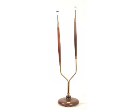 A retro mid 20th century Danish influenced floor standing standard lamp light. The lamp having twin upright teak and brass co