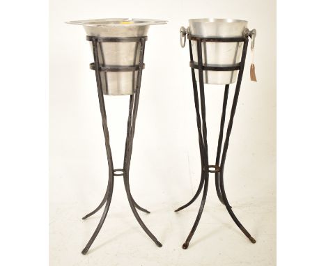 Two retro 20th century aluminum champagne ice buckets. Each in a twisted cast iron stand with one ice bucket having four flut