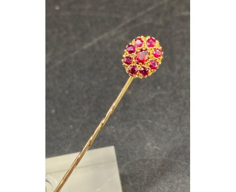 A antique fine ruby stick pin surrounded by ruby cluster in high carat gold