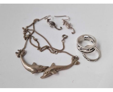 A silver dolphin necklace ring and earrings and another silver ring