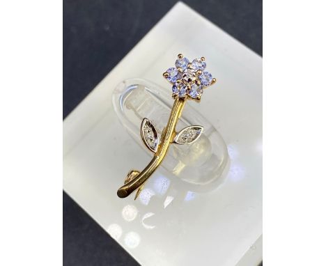 A pretty diamond and tanzanite flower brooch