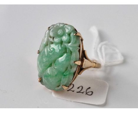 A CARVED JADE RING SET IN GOLD SIZE O 8.8 GMS