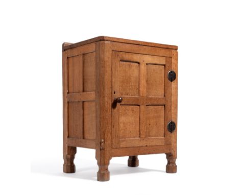 A Robert ''Mouseman'' Thompson Oak Bedside Cupboard, the raised up stand above a single panelled door, with wrought iron hing