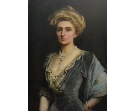 Attributed to Harrington Mann (1864-1937) Portrait of an elegant lady, half length, wearing a pearl necklace and a slate grey