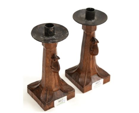 A Pair of Robert ''Mouseman'' Thompson Oak Candlesticks, with wrought-iron sconces, of octagonal form on square bases, each w