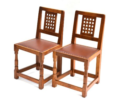 A Pair of Robert ''Mouseman'' Thompson Oak Lattice Back Chairs, on two octagonal front legs with rush rail set between, each 