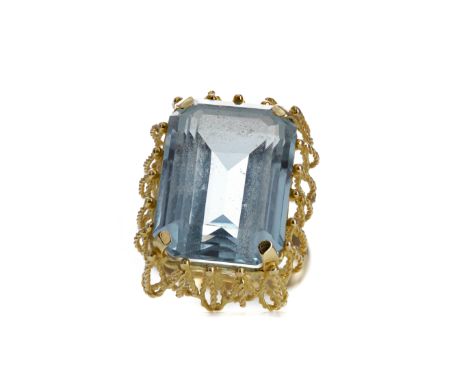 LARGE BLUE GEM SET RING, set with an octagonal step cut blue gem 18.2mm long, to an openwork mount, marked 18K to the outer s